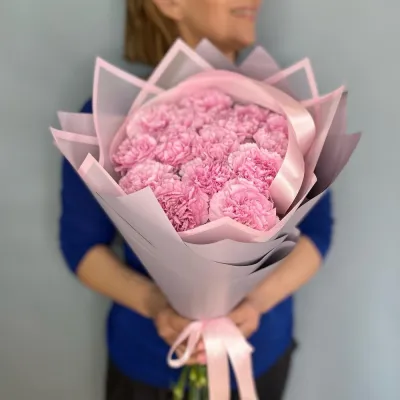 Ярко розовые гвоздики 15 шт в руках